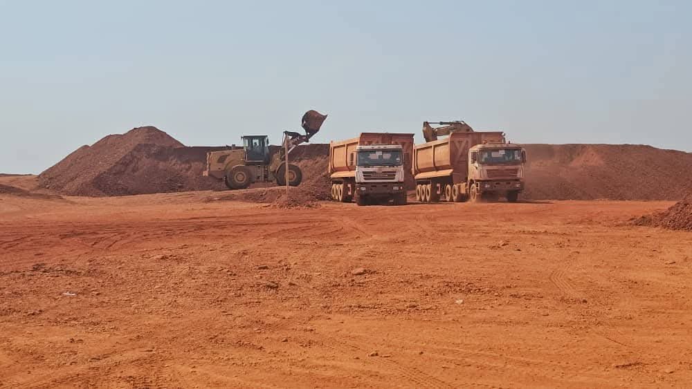 Wheel loader filling dump trucks with ore at an Alham Exim partner mine