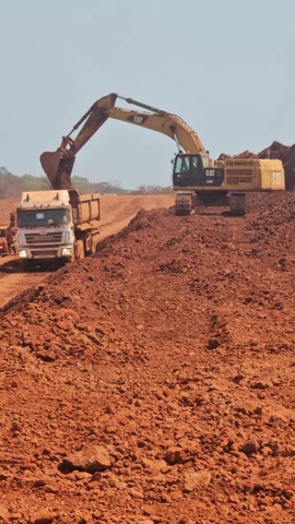 CAT excavator working red iron ore mine face